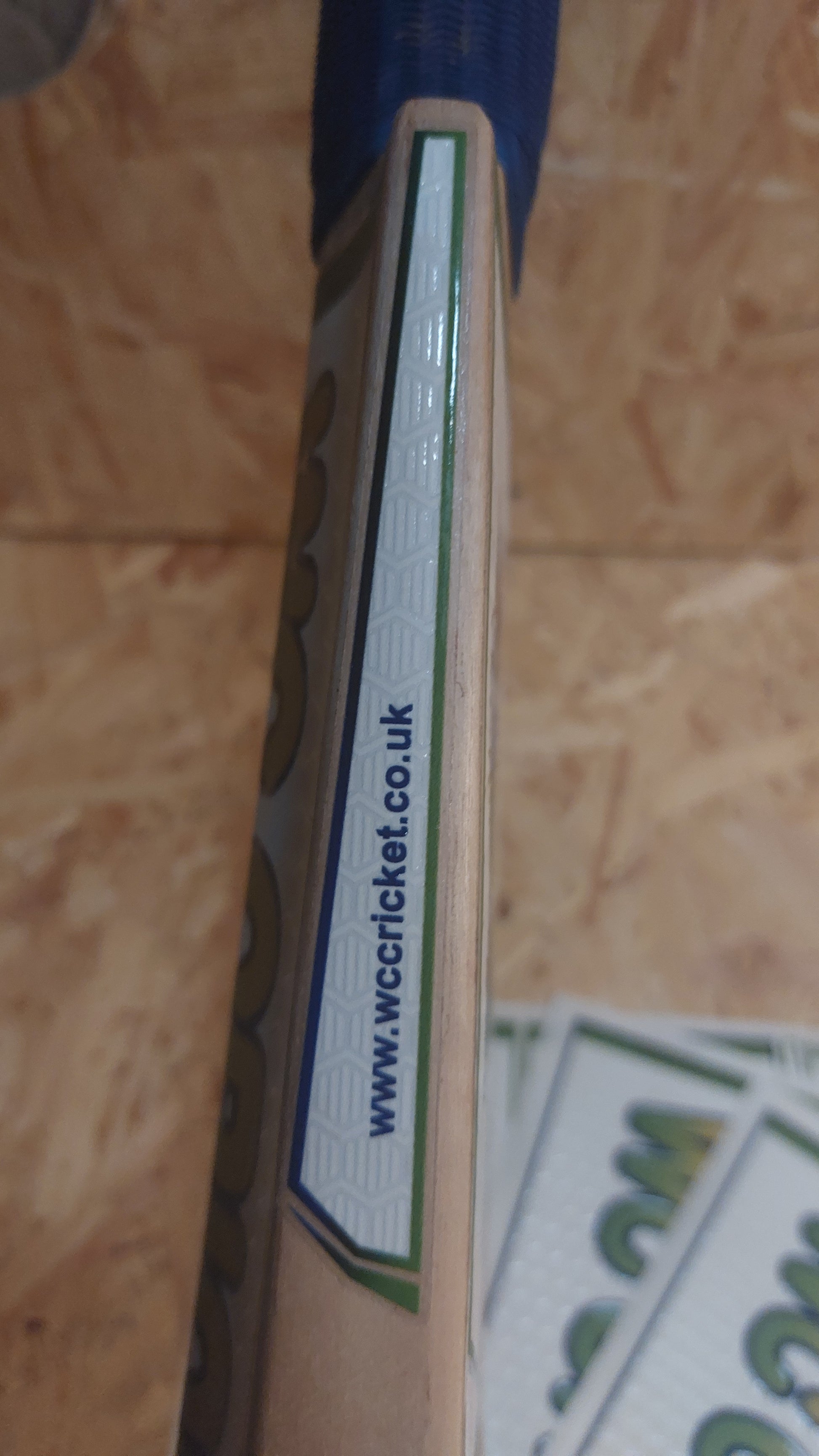 Side cricket bat sticker on a WC Cricket branded cricket bat