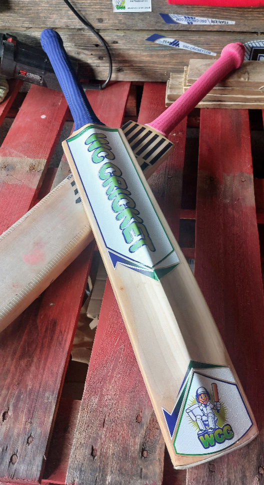WC Cricket restoration showing two willow bats with blue and pink grips on a pallet during cricket bat sticker removal