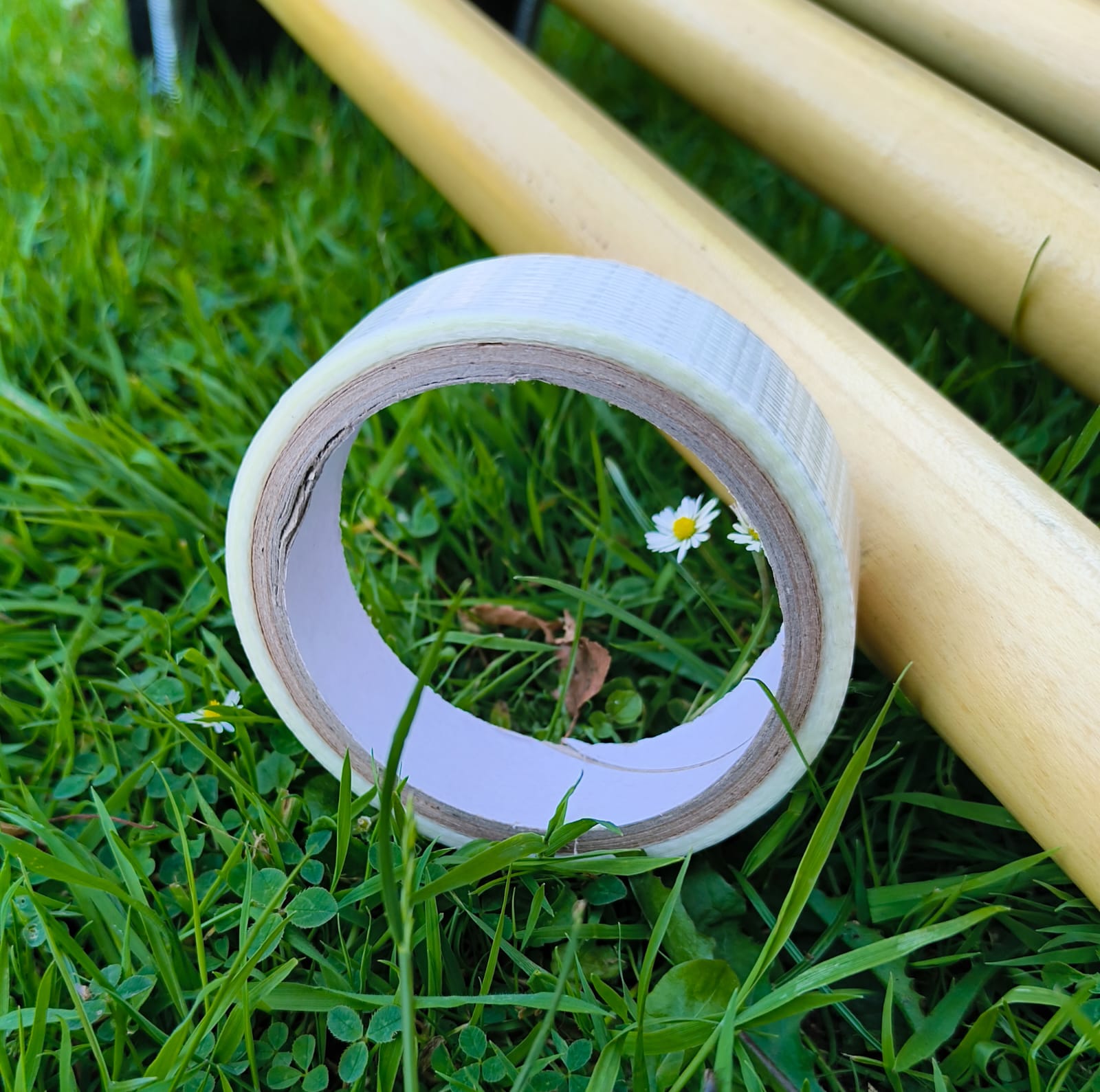 WC Cricket white roll of cricket bat repair tape on grass beside wooden stumps for field repairs