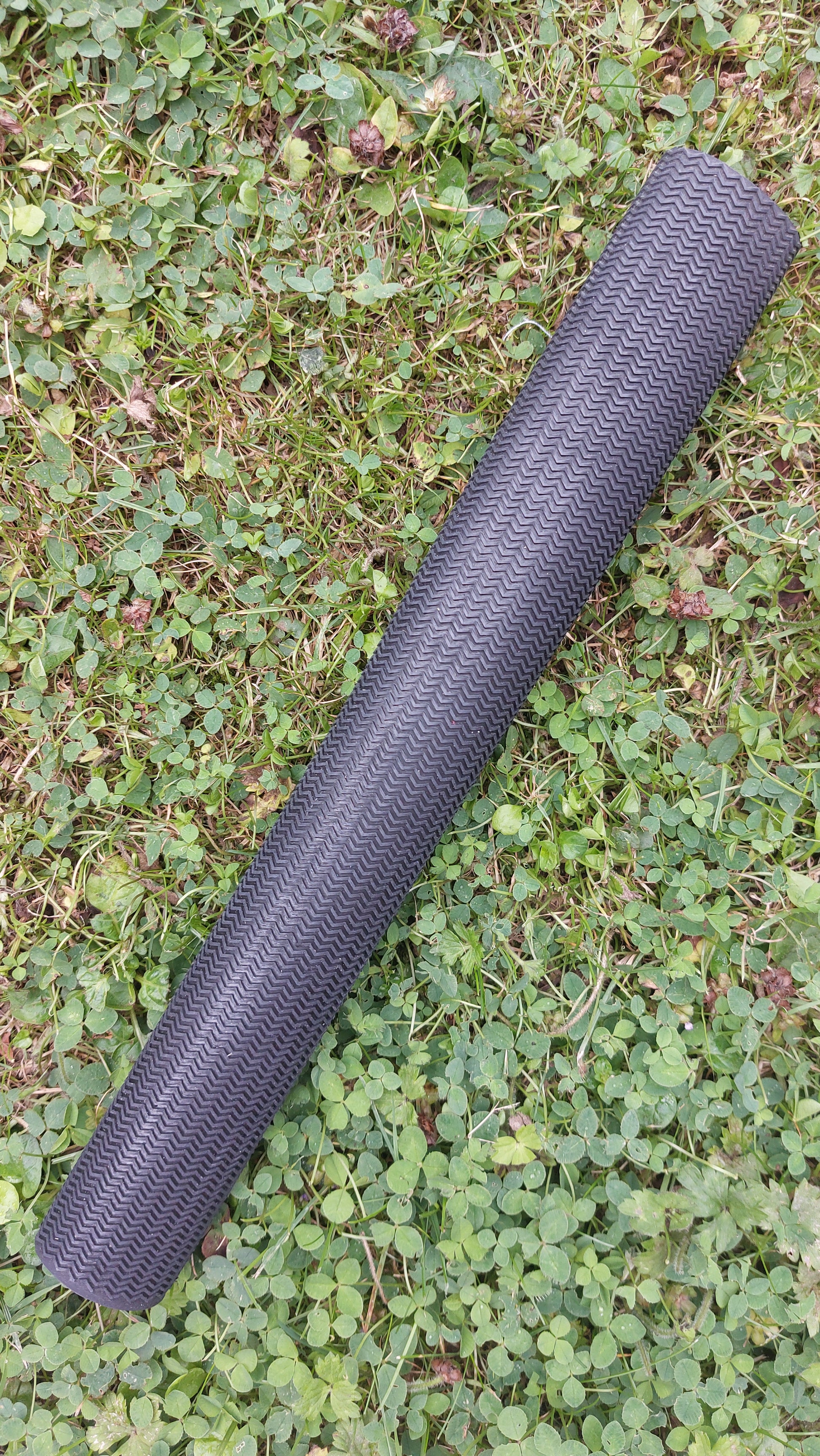 WC Cricket chevron cricket bat grip replacement roll in black showing textured pattern on grass