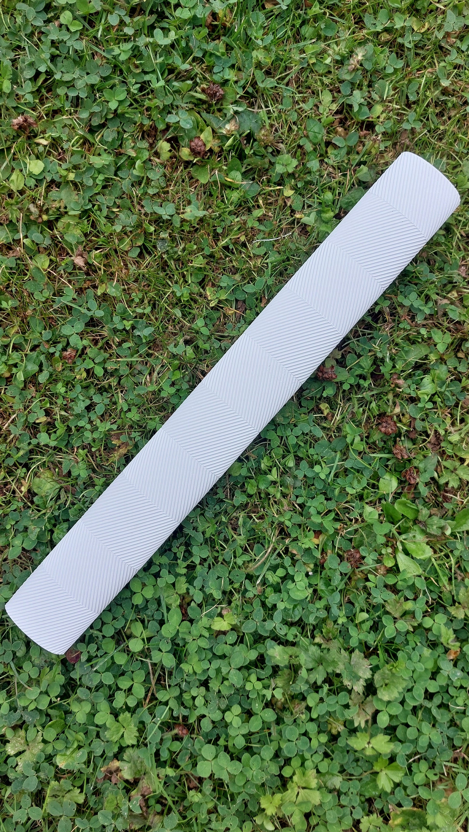 WC Cricket white chevron cricket bat grips roll on grass showing textured white replacement grip for bats