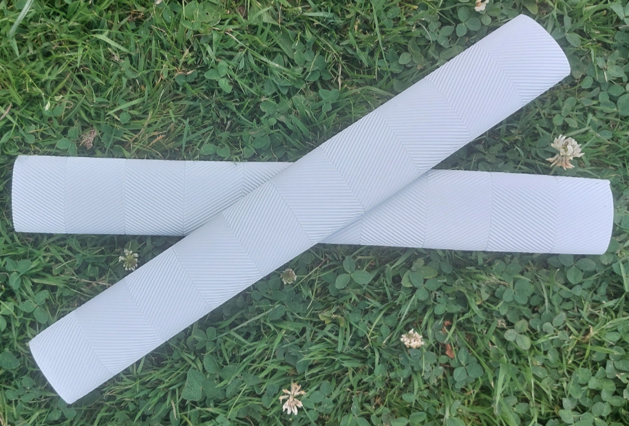 WC Cricket white chevron cricket bat grips two grips crossed on grass showing chevron texture